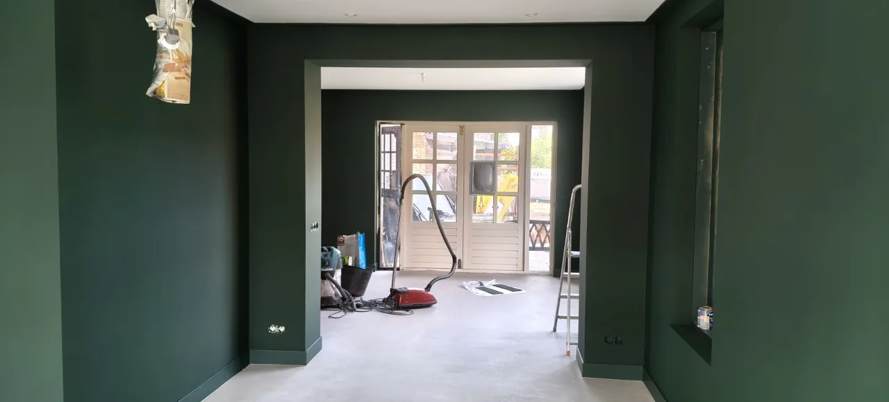 Groene binnenwanden en een doorkijk naar een ruimte met werkmateriaal