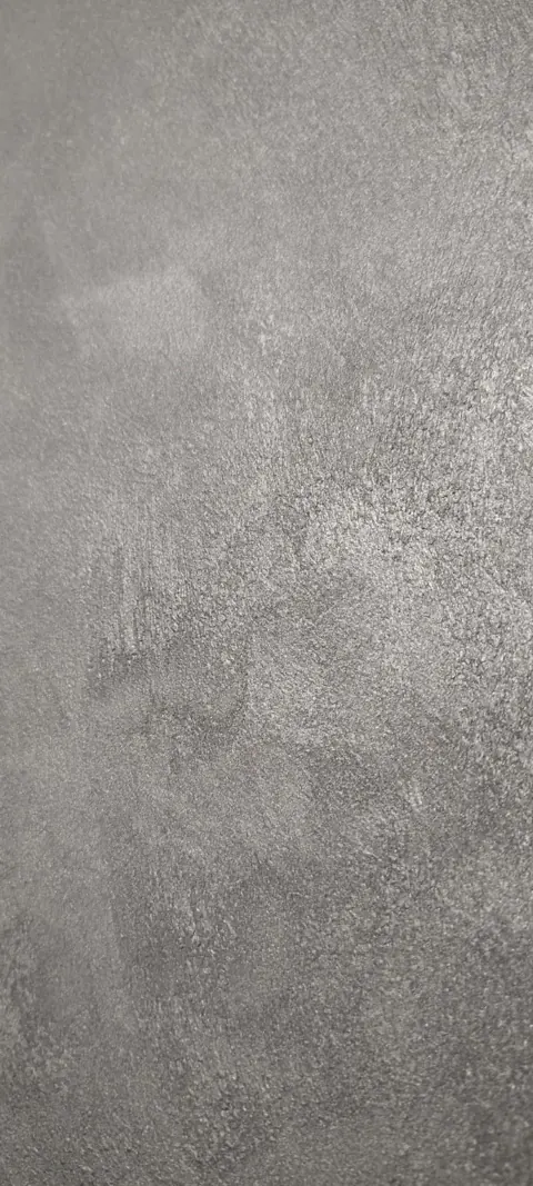 Detail van een decoratieve wand met fijne structuur en lichtreflectie