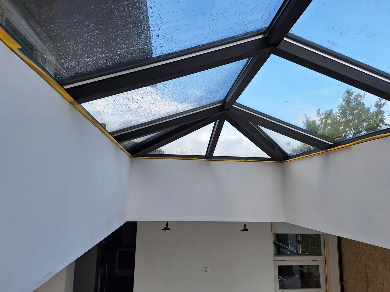 Lichte binnenruimte met witte wanden en een glazen dak