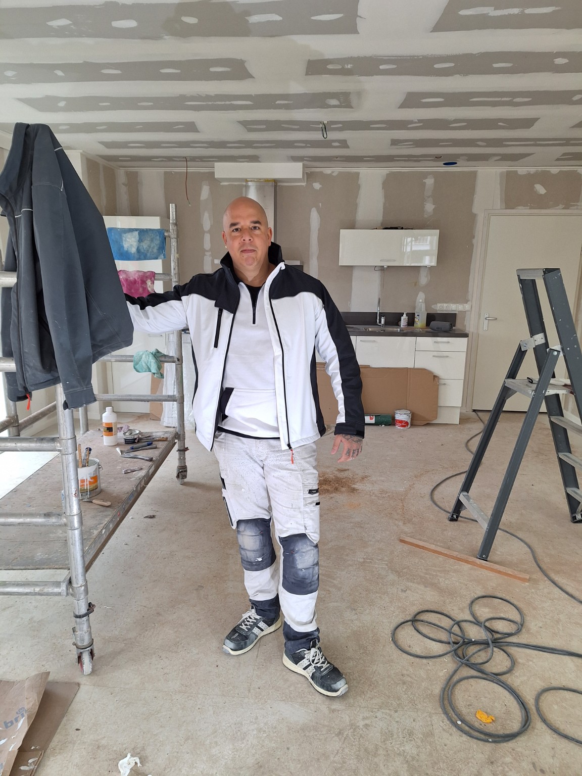 John Toering, oprichter van T. Services, in werkkleding op een binnenwerkproject